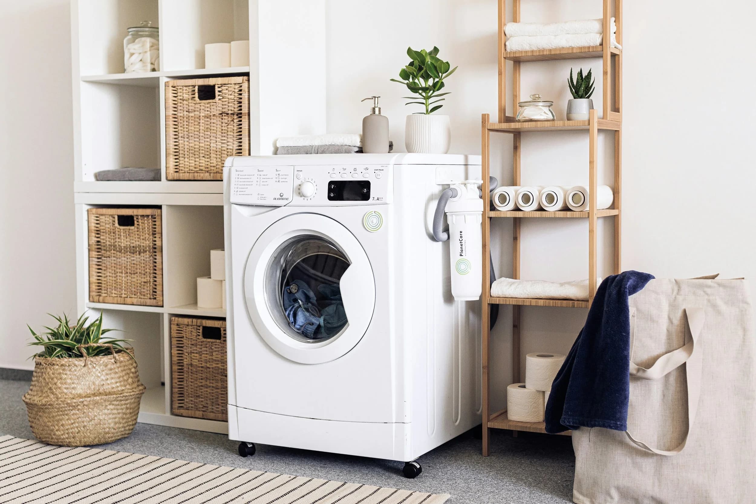 A front-loading washing machine beside open shelving